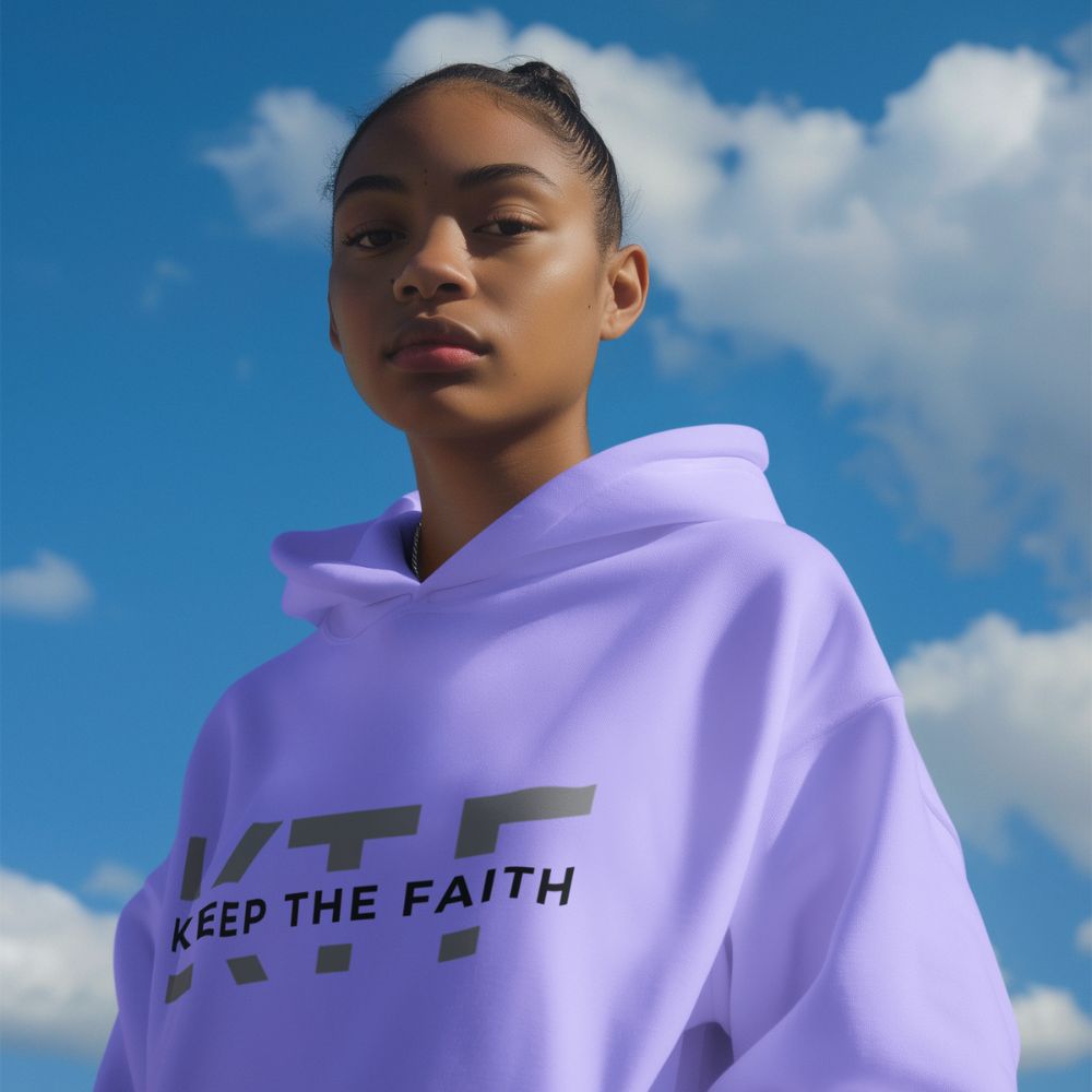 Young woman wearing lavender Keep The Faith hoodie outdoors under blue sky