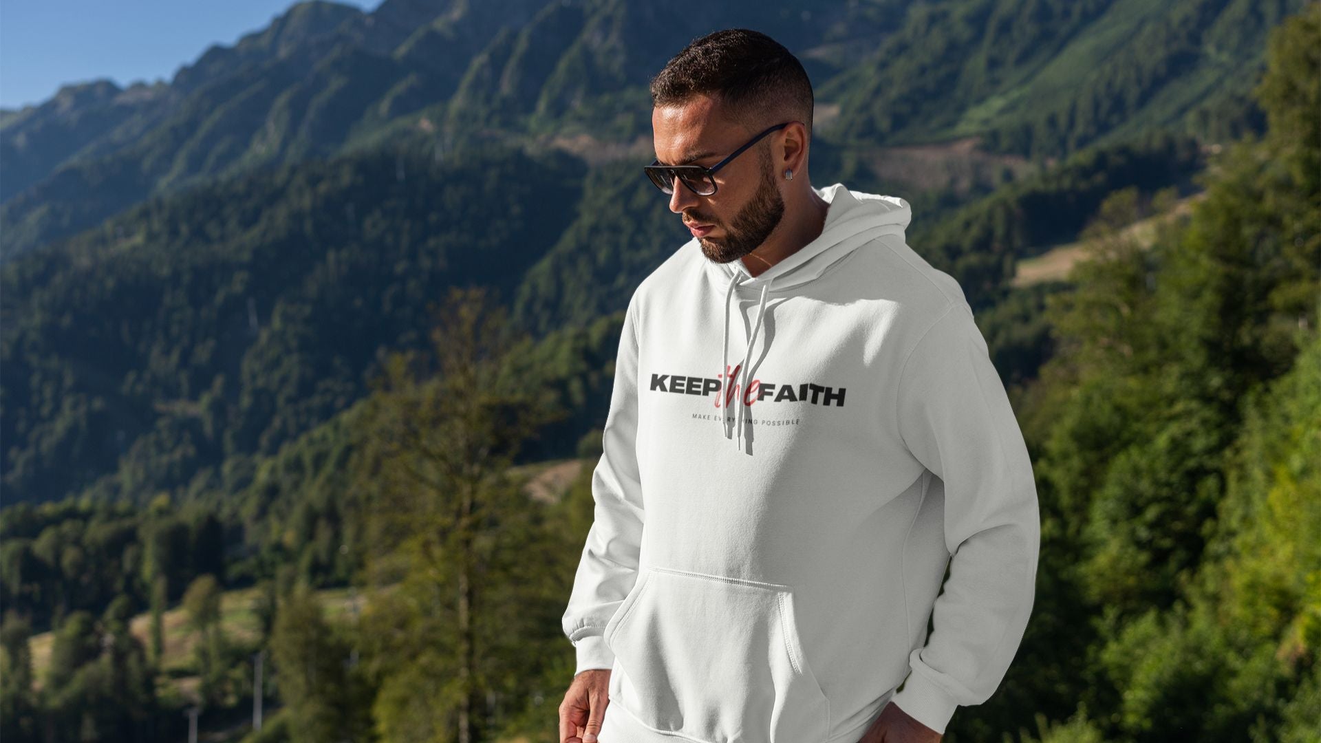 White Keep The Faith hoodie worn by man outdoors in mountain landscape